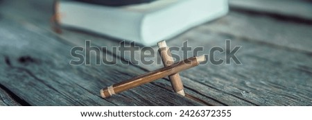 Close-up shot of holy bible with cross on wooden table. 