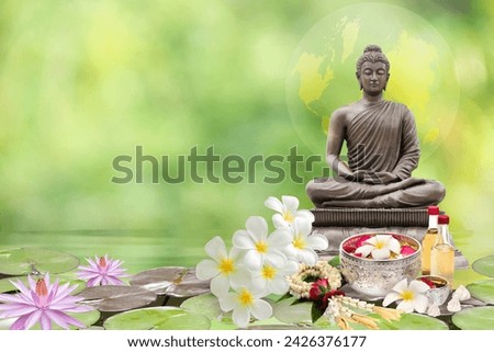 Buddha statue, flower water, Thai perfumed water and white clay filler on natural background.Songkran festival concept.