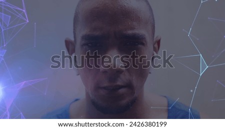 Image of glowing purple and blue networks over portrait of determined male athlete exercising. sport, achievement and communication technology concept, digitally generated image.