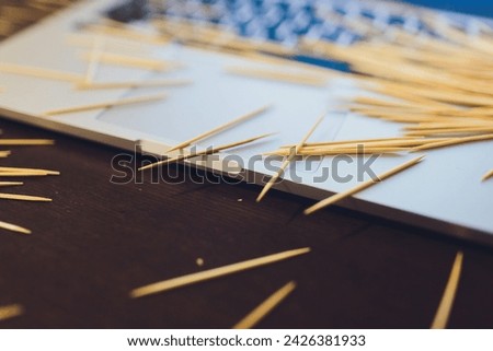 many wooden toothpicks on the brown table background a laptop