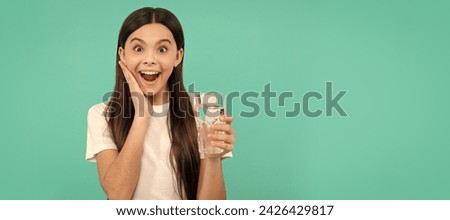 surprised child drink water to stay hydrated and keep daily water balance in body. Banner of child girl with glass of water, studio portrait with copy space. Royalty-Free Stock Photo #2426429817