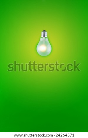 Close up of single screw base light bulb on green background.