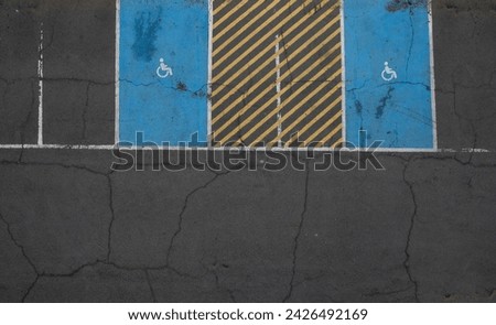 Top view of disability parking place on a parking lot. Cracked asphalt outdoor. Parking place vehicle spots.