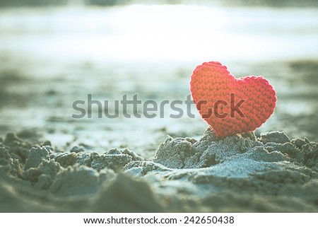 sweet heart on sand beach under sunset and warm light. abstract background love summer on the beach. vintage color tone.