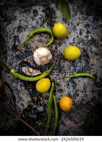 Black brown stone background, yellow lemons,green chillies and garlic pic.....
