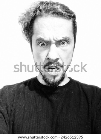 Portrait of an angry man. Black background. Model. Royalty-Free Stock Photo #2426512395