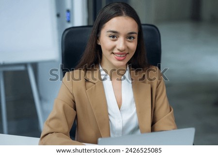 Portrait of cheerful caucasian businesswoman smiling widely with teeth against background of spacious office
