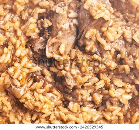 Close-up of traditional risotto with braised meat, cooked to a creamy texture in a bowl.