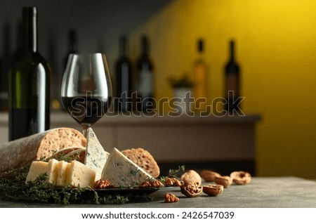 Cheese, bread, red wine, and walnuts on a kitchen table. Traditional Mediterranean snacks.