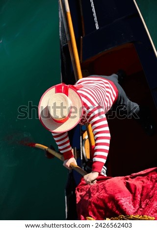 Venetian gondolier with hat rowing on gondola boat on grand canal in Venice in Italy in Europe Royalty-Free Stock Photo #2426562403