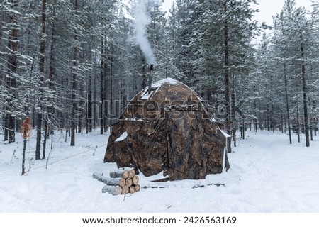 Winter camping in a snowy forest. The tent is set up in the winter forest. Winter landscape with a tent