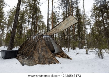 Winter camping in a snowy forest. The tent is set up in the winter forest. Winter landscape with a tent