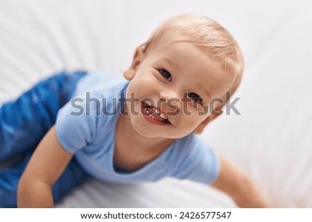 Adorable toddler smiling confident sitting on bed at bedroom Royalty-Free Stock Photo #2426577547