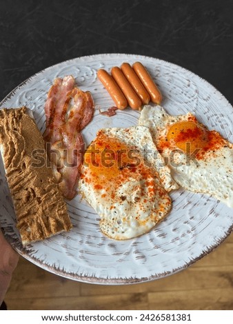 fried eggs and sausages in a frying pan, delicious and healthy breakfast
