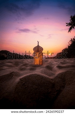 Lantern on the sand with sunset sky, Ramadan Kareem and Eid Mubarak photography Royalty-Free Stock Photo #2426590237