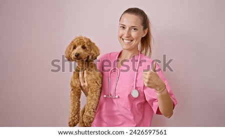 Young caucasian woman with dog veterinarian holding dog doing thumb up gesture over isolated pink background