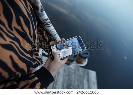 aesthetic photo. a cup of coffee in the hands of a girl. take pictures of coffee on a mobile phone