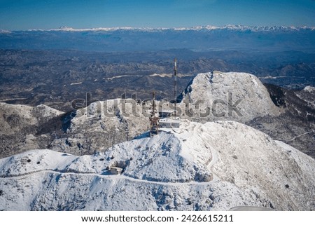 Snow-Capped Mountain Peaks and Communication Towers Royalty-Free Stock Photo #2426615211