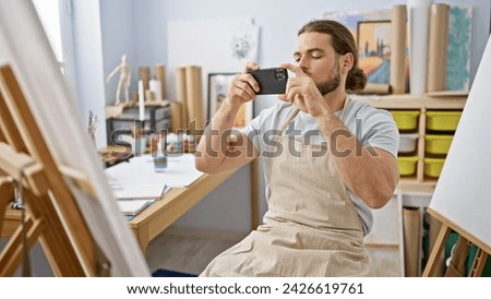 Young hispanic man artist taking picture to draw at art studio