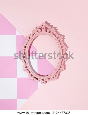 Vintage oval picture frame, pink checkered pattern background, retro style, 1950s nostalgia. Creative copy space.