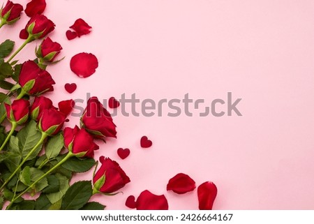 Framework made of rose flowers and hearts on pink background. Flat lay