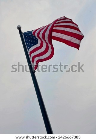 American flag framed by a blue and white sky