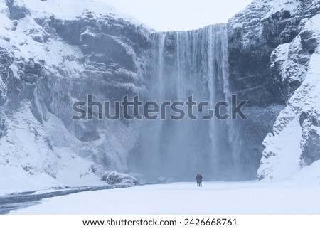 Skogafoss waterfall in winter with unidentifiable people Royalty-Free Stock Photo #2426668761