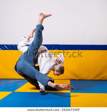 Young girls and boys practice Brazilian jiu jitsu in the gym