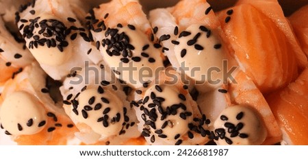 Beautiful close-up photo of sushi with salmon and shrimp. Delicious Japanese food photo in high quality. Stock photo of sushi with black sesame.