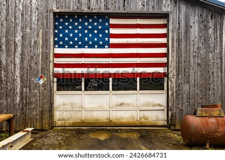 United States Red, white and Blue flag over rural wooden garage door.