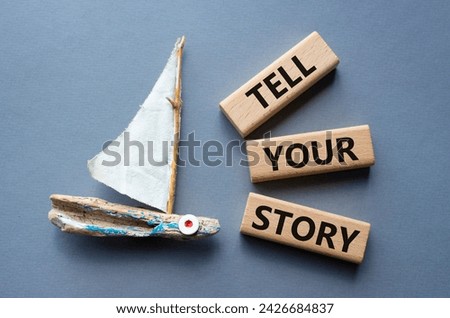 Tell your story symbol. Wooden blocks with words Tell your story. Beautiful grey background with boat. Business and Tell your story concept. Copy space.