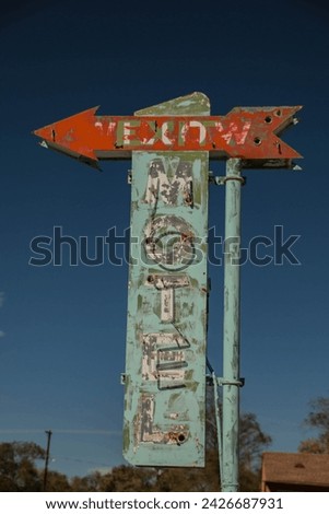 A weathered vintage hotel sign with an arrow for direction.