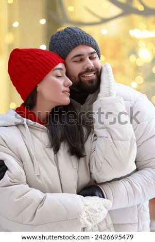 Portrait of lovely couple outdoors against blurred lights outdoors
