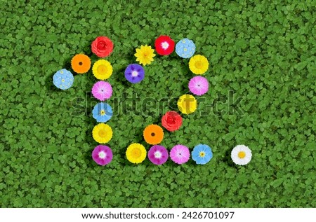 number written with colorful flowers on green clover background
