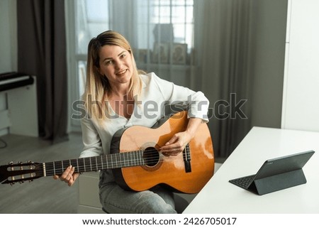 woman holding a guitar with her hands