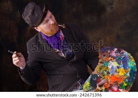 close-up portrait of the adult artist with red beard and mustache studio on dark background