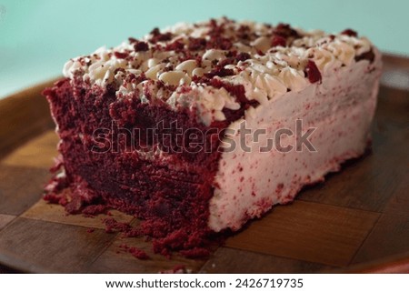 Vertical photograph without people of a slice of homemade red velvet cake baked inside a kitchen for a celebration