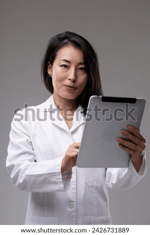 Doctor with a tablet likely navigates through patient information, a symbol of modern healthcare's digitization Royalty-Free Stock Photo #2426731889