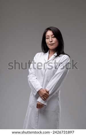 Serene medical practitioner in white, hands clasped, displays a calm confidence and ready expertise Royalty-Free Stock Photo #2426731897
