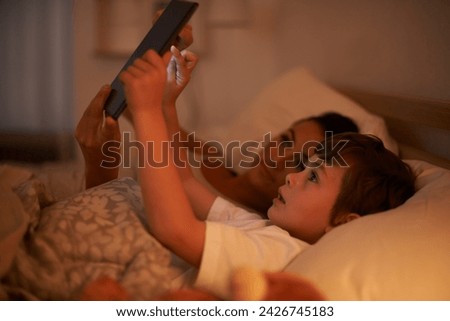 Bedroom, mother and son with tablet, night and family with ebook and connection with social media. Mama, home and boy with technology or bedtime story with lights or bonding together with digital app