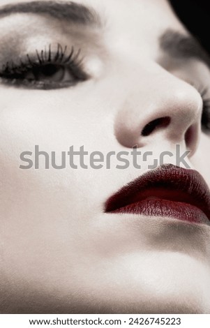 Woman, studio and face closeup in gothic makeup for beauty, cosmetics and zoom of skincare with dark aesthetic. Young model with red lipstick for cool, art or Victorian style on a black background