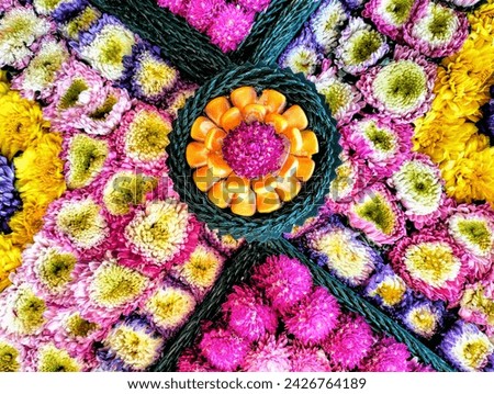 In the picture is In the picture, fresh, artificial flowers are beautifully decorated in floral decorations. There are purple, orange, pink and amaranth carnations, orange corn seeds.