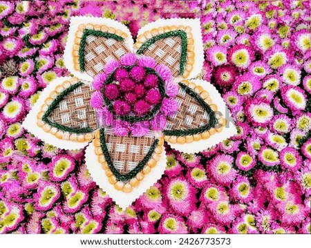 The background picture is a pink carnation flower in the center, made from bamboo woven into the shape of a five-petal flower, adding pink carnation flowers and orange corn seeds.