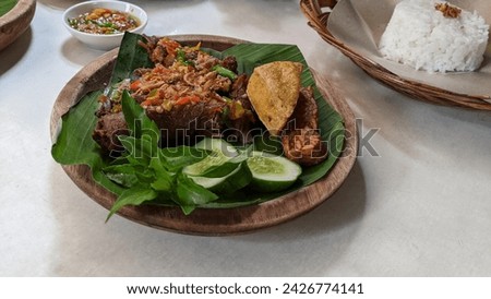 Closeup picture of Ayam goreng kremes dish on the wooden plate.