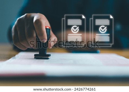 Businessman using rubber stamping on paper with correct sign mark symbol and electronic doc icon for document approve and project pass concept. Royalty-Free Stock Photo #2426774261