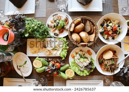 A table covered with a wide variety of delicious dishes and plates, ready for a sumptuous feast. Royalty-Free Stock Photo #2426785637