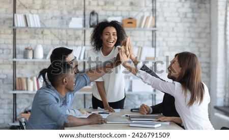 Company workers having fun in team building meeting. Smiling business mentor inspiring office staff to cooperate effectively. Happy manager high-fiving employees, encouraging them for productive work Royalty-Free Stock Photo #2426791509
