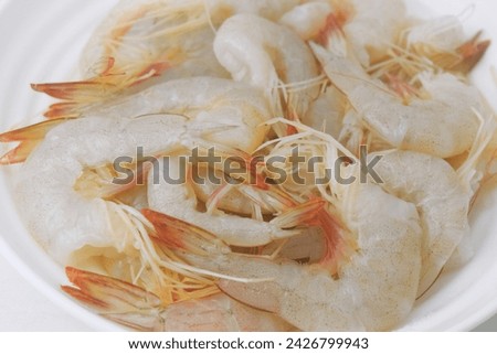 Close Up photo of very fresh reddish-white raw tiger prawns. Isolated white background