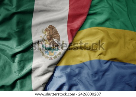 big waving national colorful flag of gabon and national flag of mexico . macro