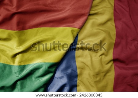big waving national colorful flag of romania and national flag of bolivia . macro